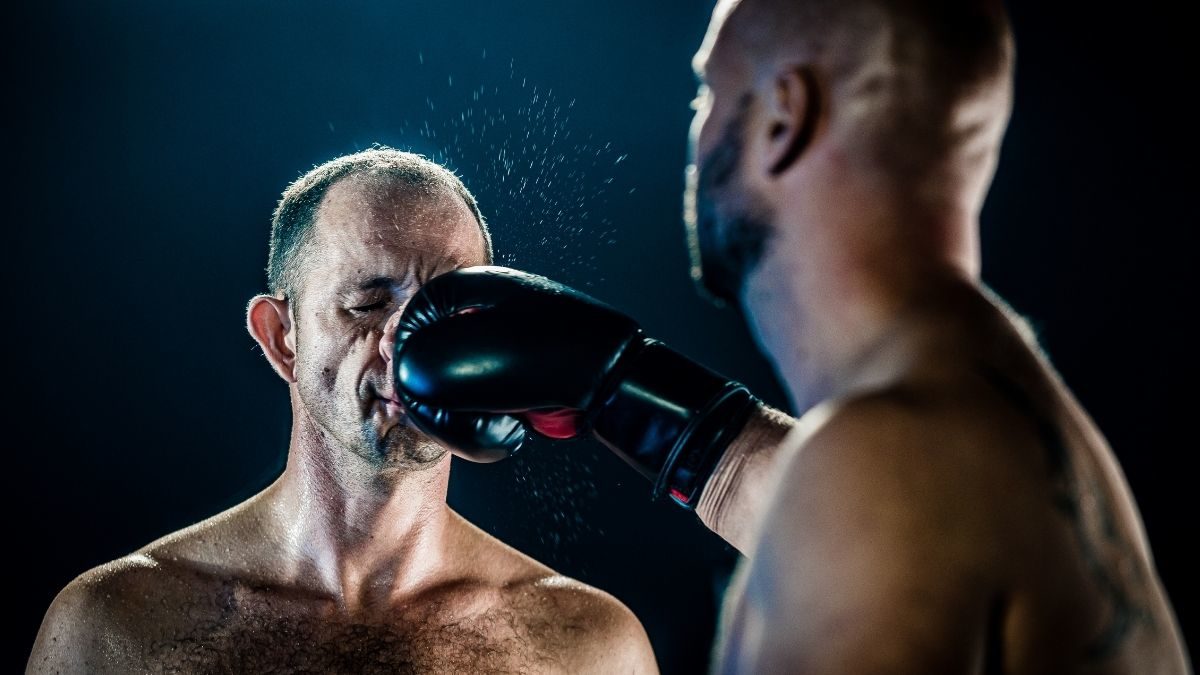 A fighter taking a punch to the nose and face from another fighter