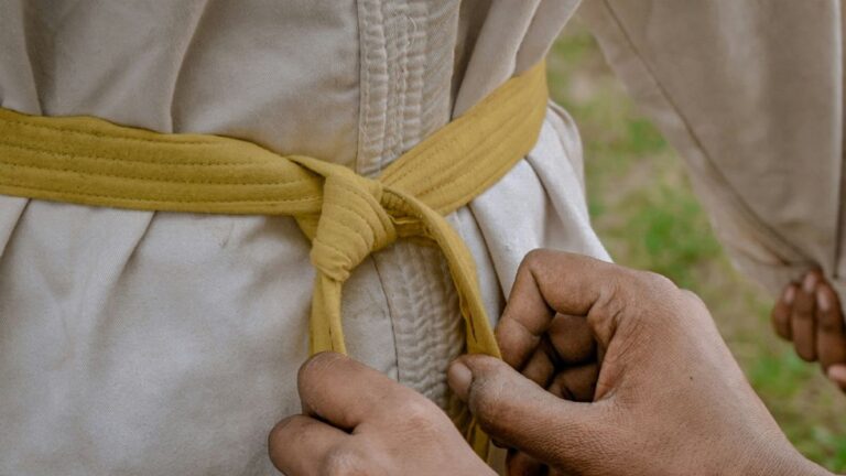 tying yellow karate belt around the waist