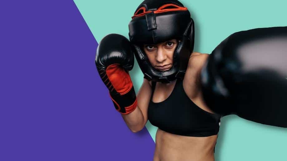 A female boxer wearing gloves and headguard