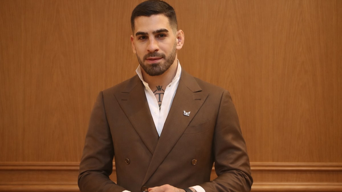 ilia topuria posing wearing suit